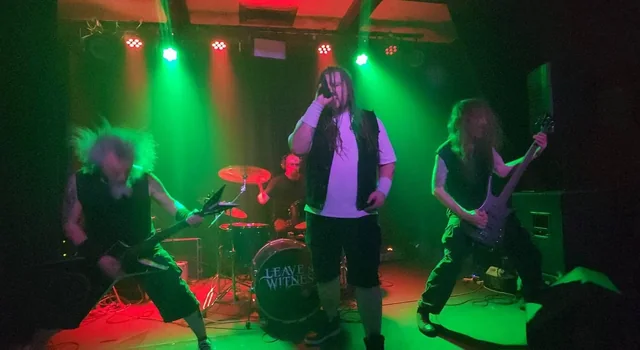Ashborn vocalist, guitarists and drummer under green and red stage lights
