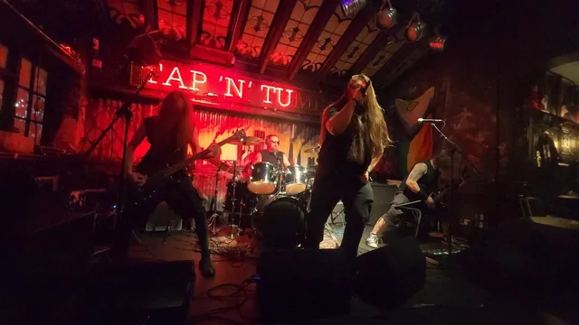Ashborn performing on a small stage under red lights